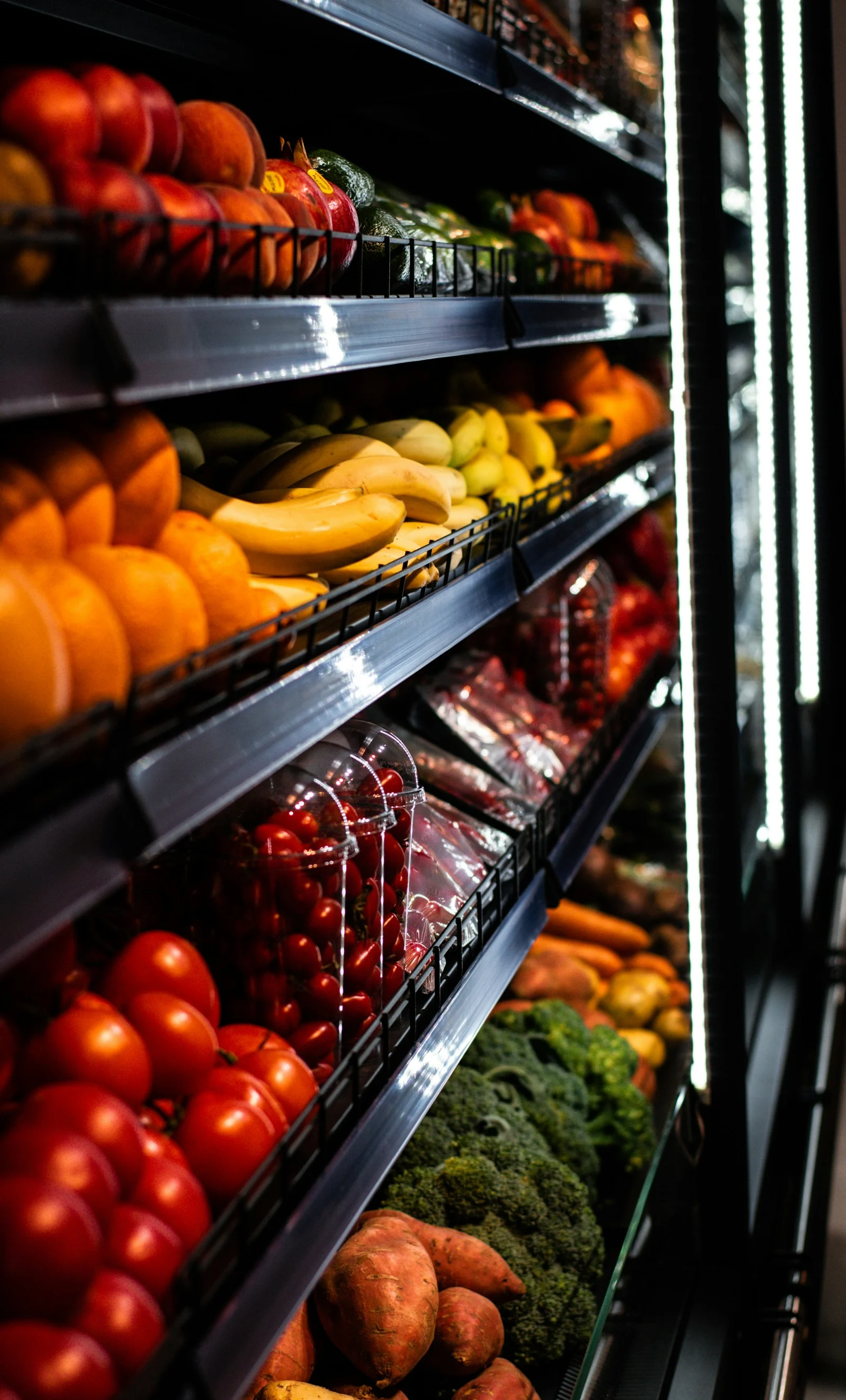 A display in a grocery store filled with lots of fruits and vegetables;第三方摄影参考