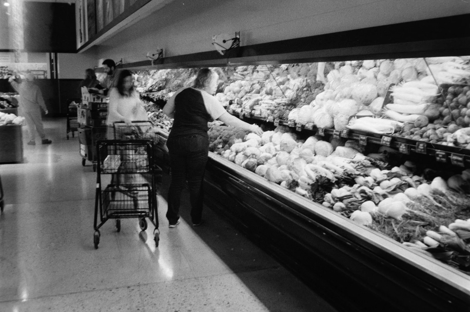 People shopping for produce in a grocery store.；第三方摄影参考