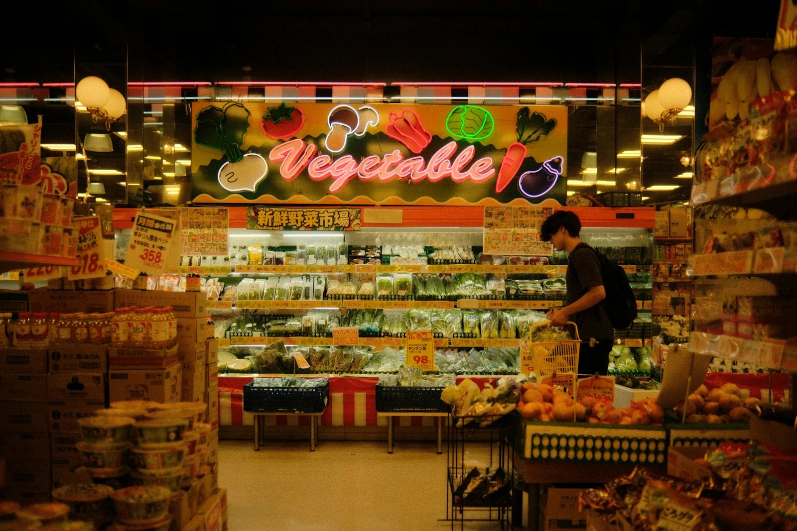 A person shopping in a supermarket vegetable aisle.；第三方摄影参考